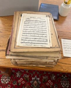 A pile of aged and tattered sheet music.