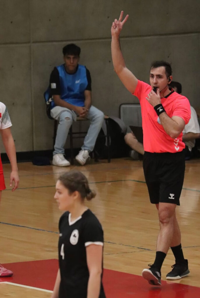 A photo of a handball referee making a call