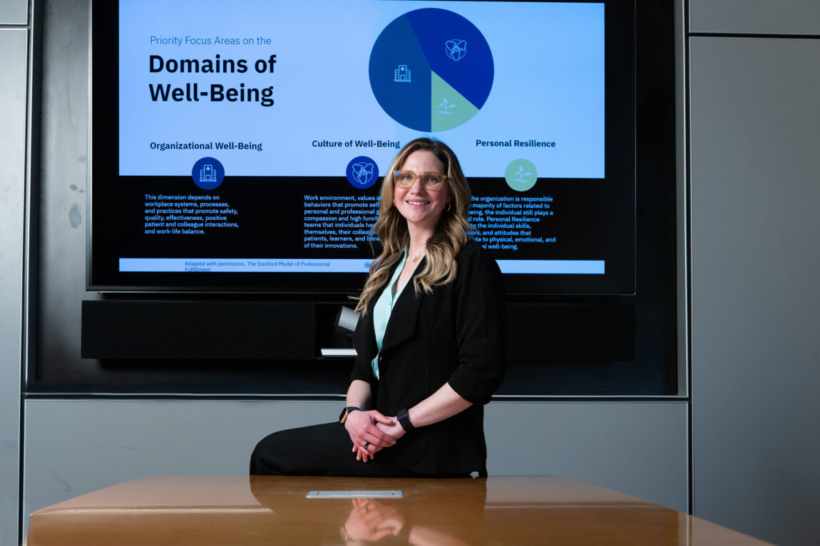A photo of a woman sitting in front of a screen