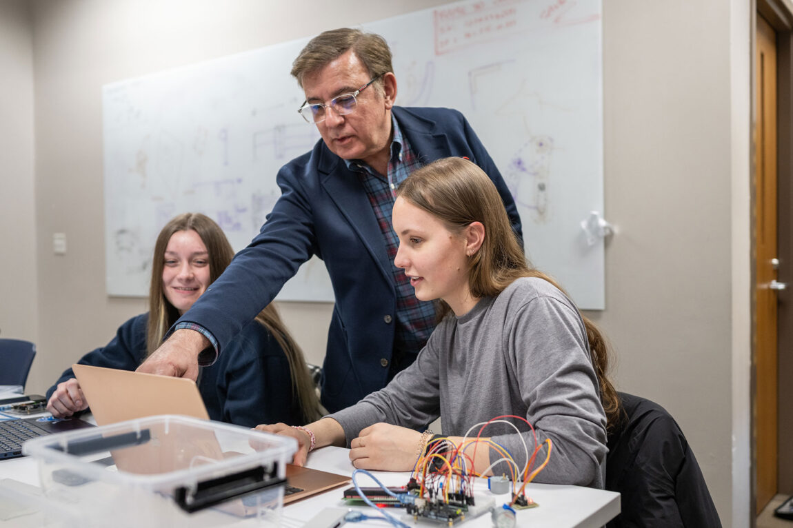Photo of Kas Kasravi, lecturer III in industrial and manufacturing systems at UM-Dearborn, working with students in his prototype-design lab 