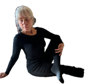 Person sits on the floor with one leg crossed over the other knee