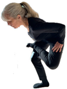 Person crouches as though sitting with one leg crossed over the other