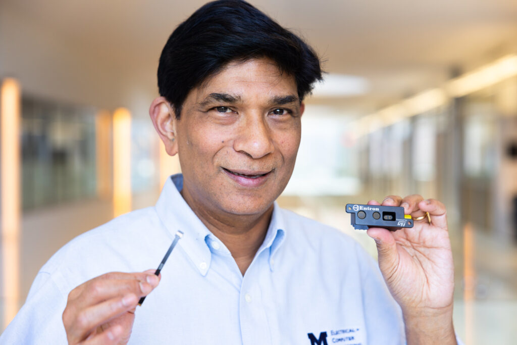 Professor of Electrical & Computer Engineering, Mohammed Islam, holds a prototype development kit of a hybrid camera (right) and a 'direct time of flight' sensor, (left) a sensor found in smartphone cameras for proximity sensing. Image credit: Jeremy Little, Michigan Engineering
