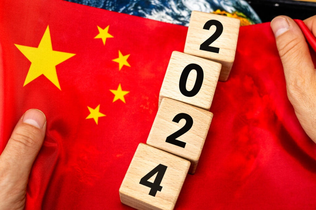 Chinese flag held in hands with block numbers 2024. Image credit: iStock