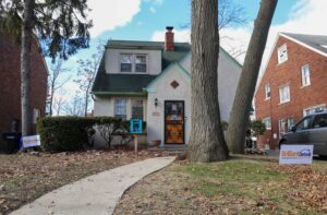 Two story stucco house with Brilliant Detroit lawn sign.