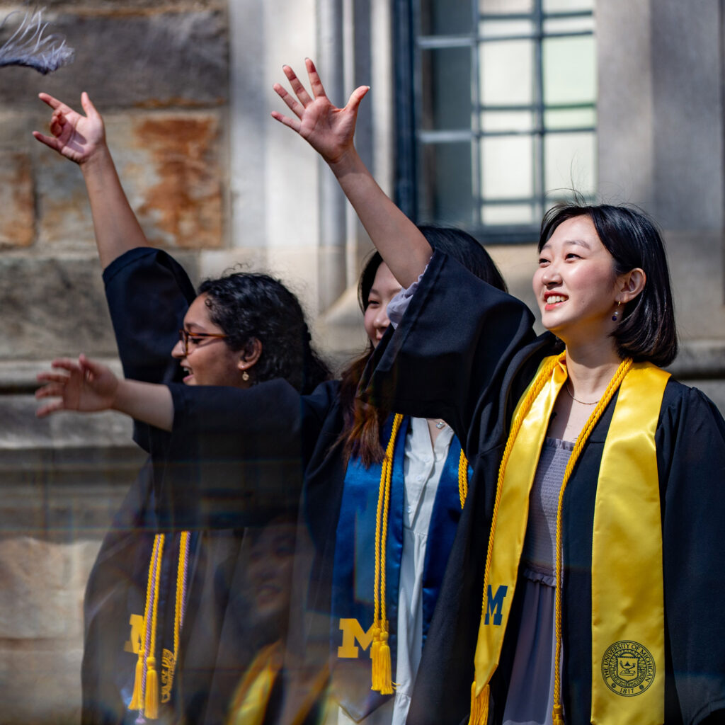 Photo of women graduates waving
