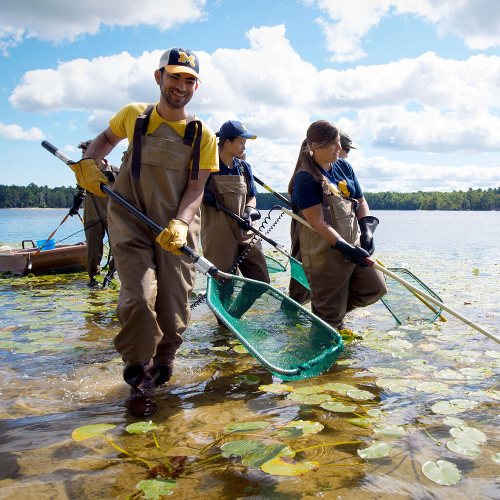 Photo of students with fishing nets in water