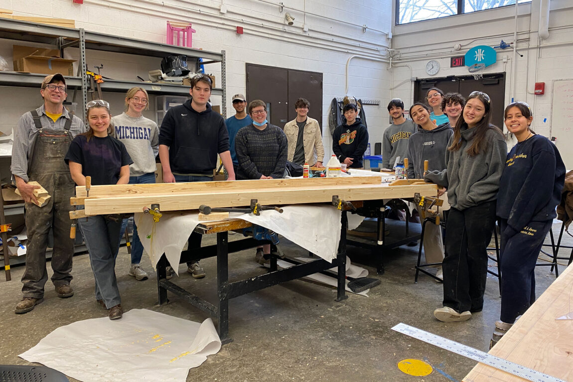 Photo of associate professor Joseph Trumpey (far left) and students in his Tree to Table class posing with one of their projects, a conference table.