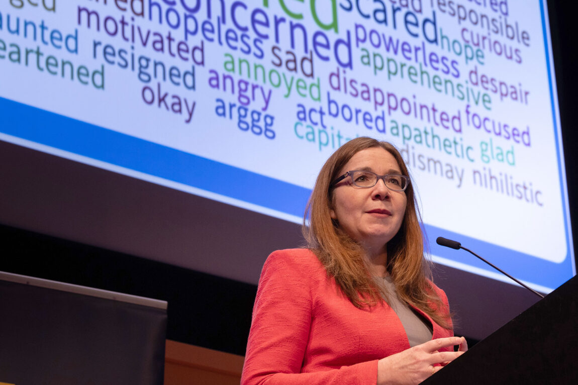 Wege Lecturer Katharine Hayhoe speaking in front of a "word cloud"