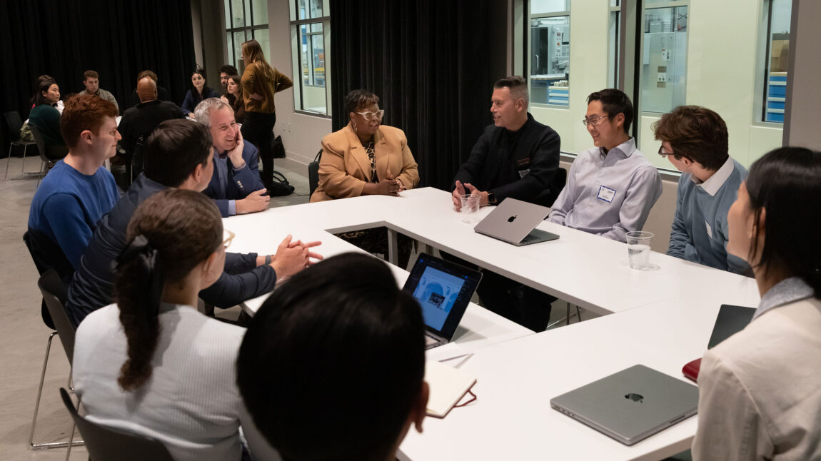A photo of several people seated at a table talking