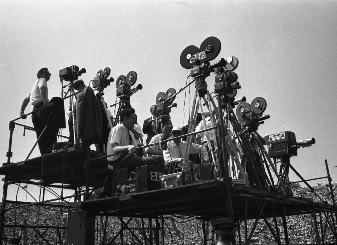 A photo of media members and television cameras capturing Lyndon Johnson's remarks in 1964