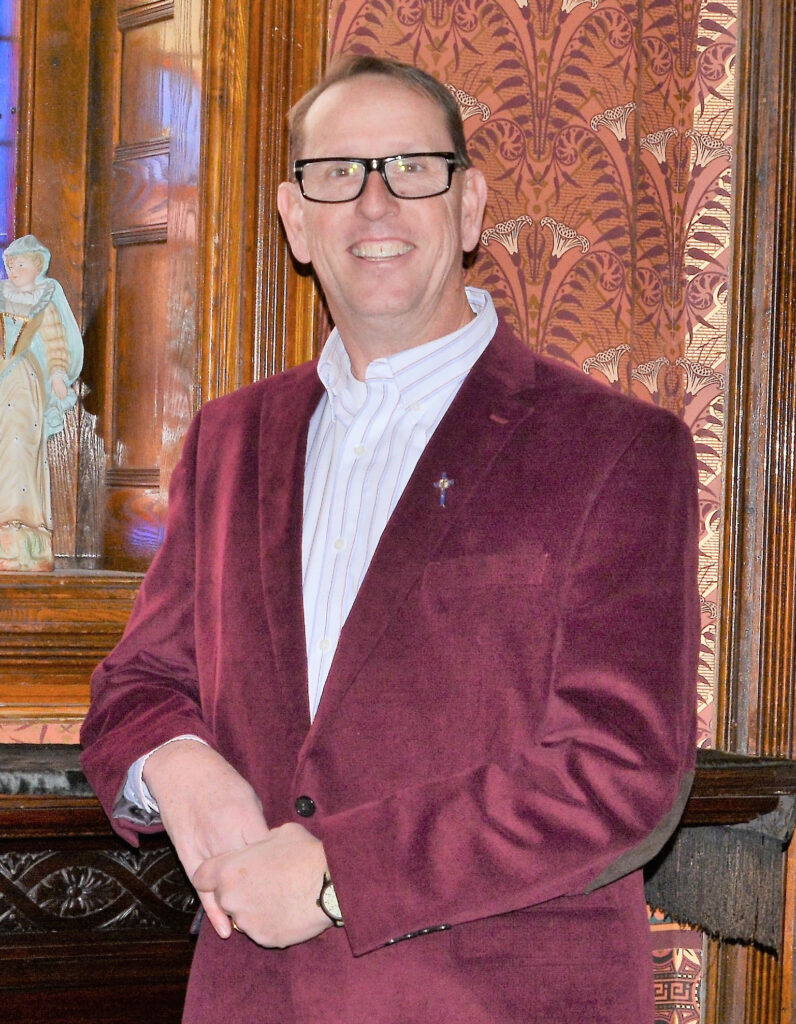 A photo of a man in a suit coat