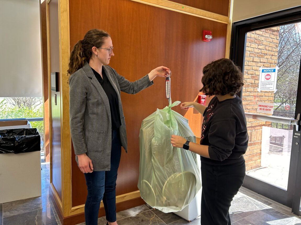 A photo of two women weighing a bag