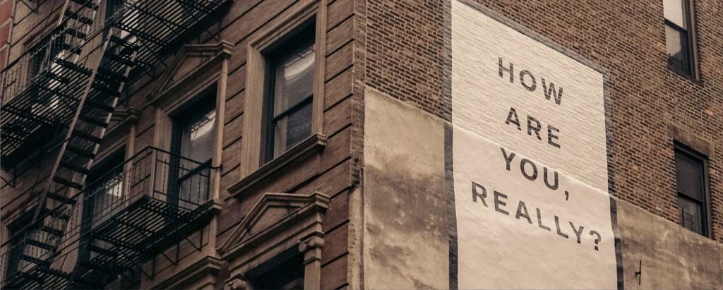 Corner of a building with a painted message reading "How are you, really?". Image courtesy: DMACS