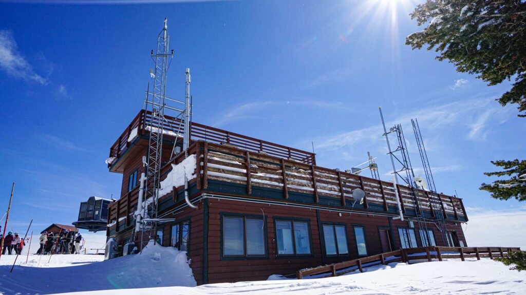 The outside of storm peak lab resembles a cabin at a ski resort, except it has several metal radio towers with instruments that collect data on the properties of clouds and snow.