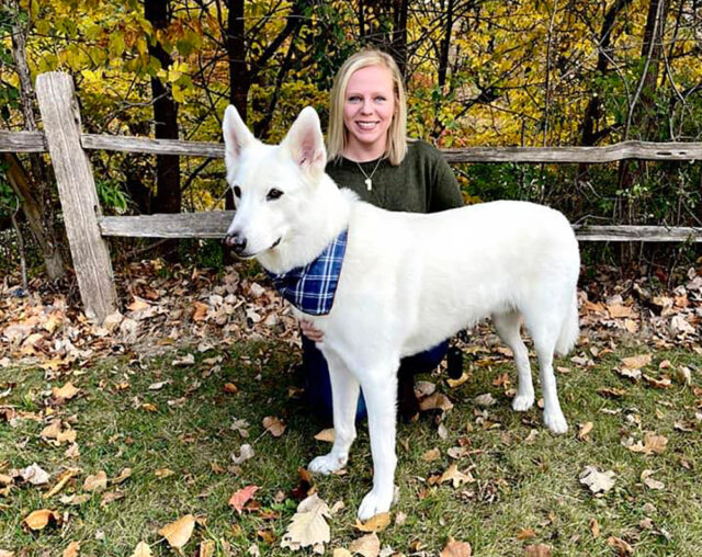 A photo of a woman and a white dog