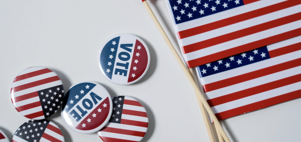 Small American flags and voting buttons arranged on a white background.