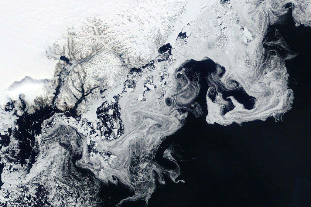 White wisps and spots swirl against the deep blue ocean.