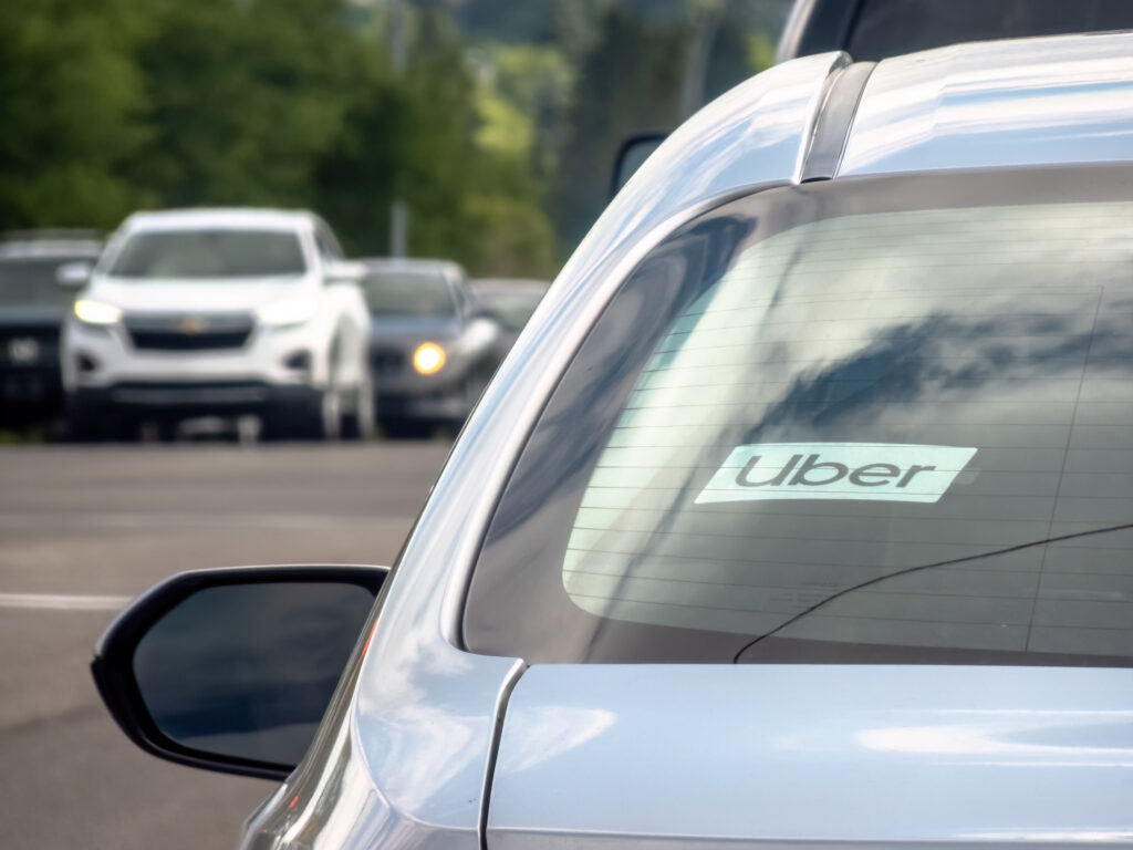 A close up to an Uber sign on a vehicle car on the road. Image credit: iStock