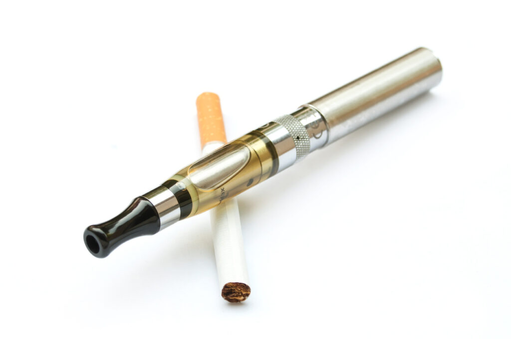 E-cigarette closeup with cigarette on white background. Image credit: iStock