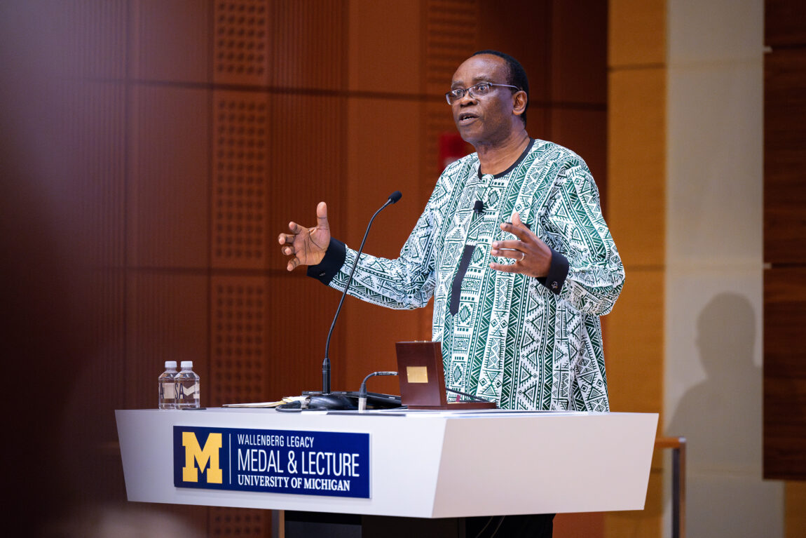 A photo of a man delivering a speech behind a lectern.