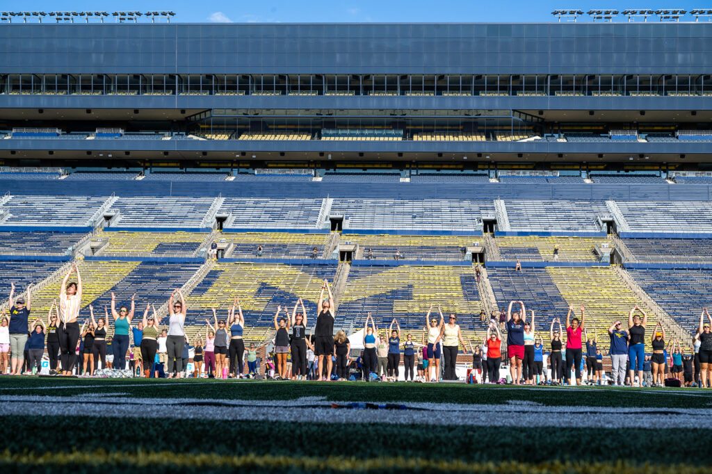 Photo of people doing yoga on the football field.
