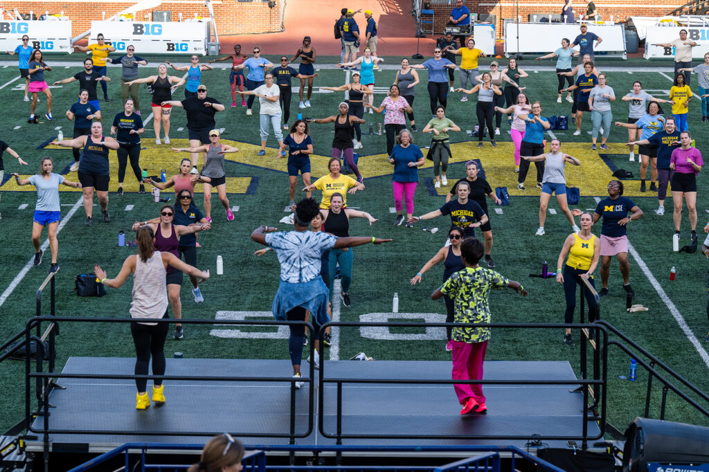Photo of people taking a Zumba class on the Michigan Stadium football field