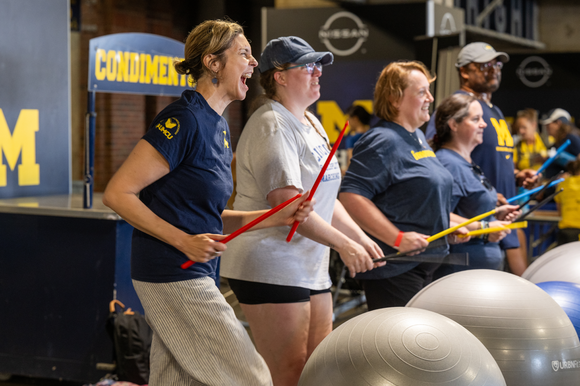 Photo of women drumming on large rubber balls.
