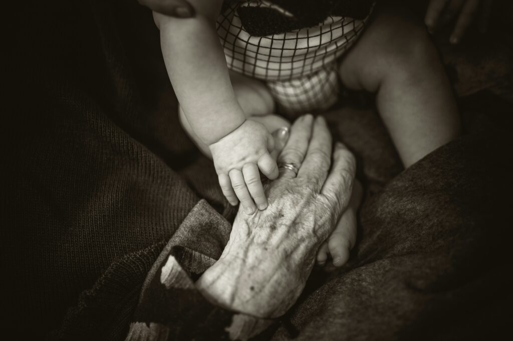 Older woman holding hands with grandson.