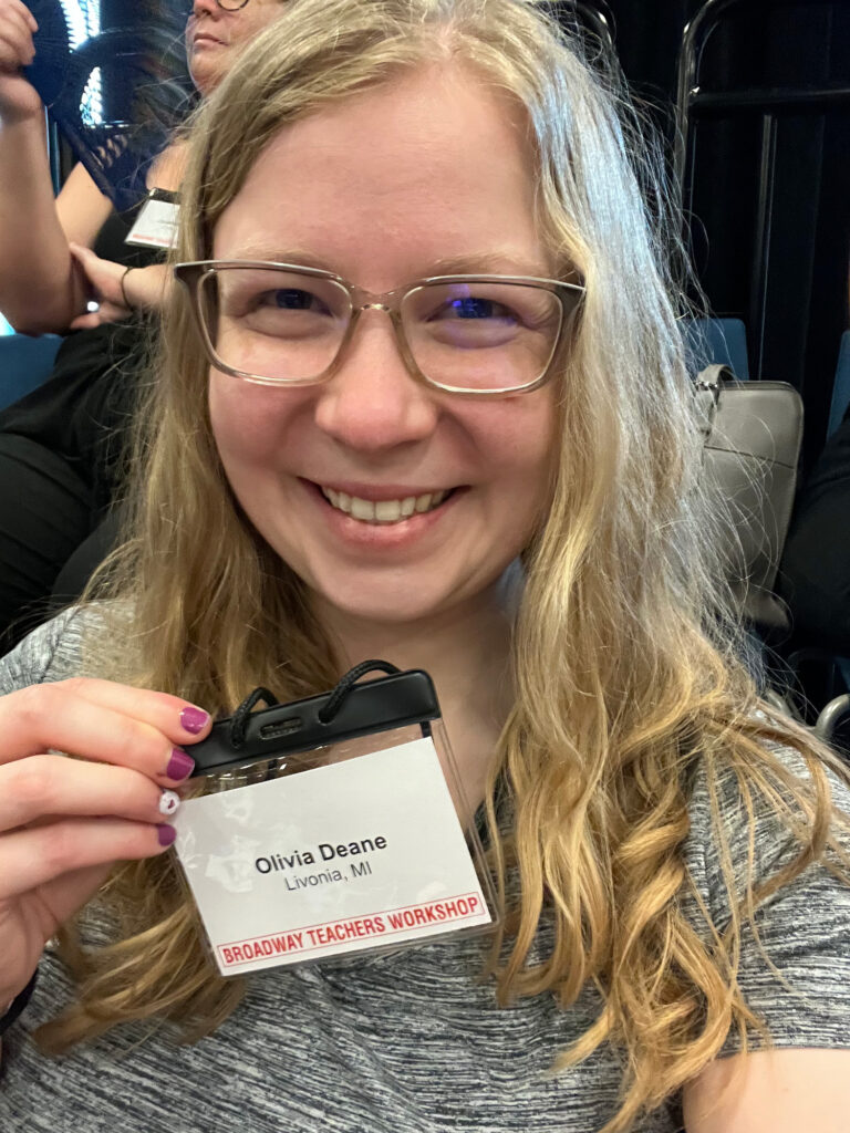 A photo of a woman holding up her nametage