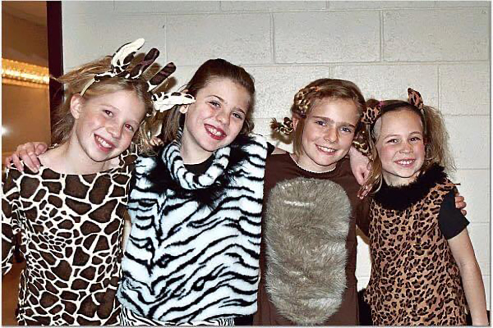 A photo of four girls who were castmates in a play