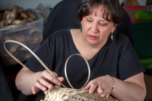 Photo of a woman weaving a basket