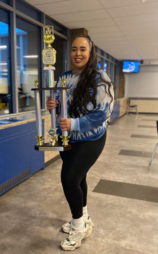A photo of a woman holding a large trophy