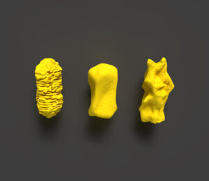 Three gold nanoparticles are neatly arranged in a row. From left to right, the nanoparticles look like: a gold rod with many finely etched grooves in the surface, a dented cylinder and a crumpled oval with many divots.