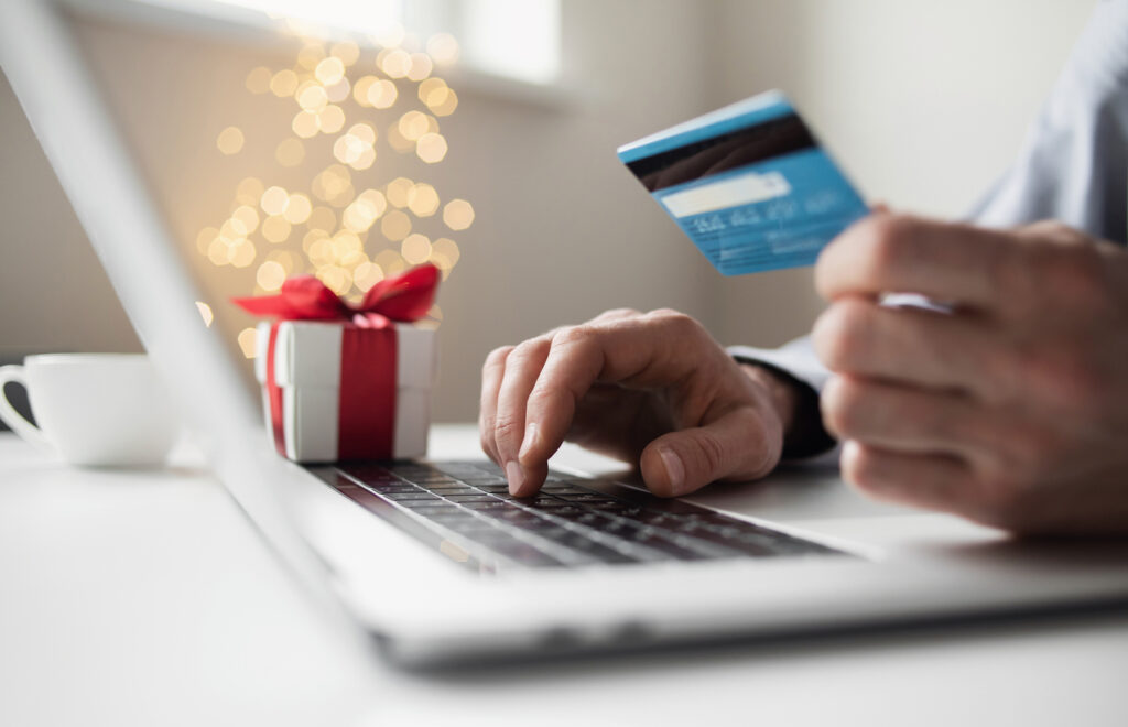 Man ordering Christmas gift using laptop and credit card. Image credit: iStock