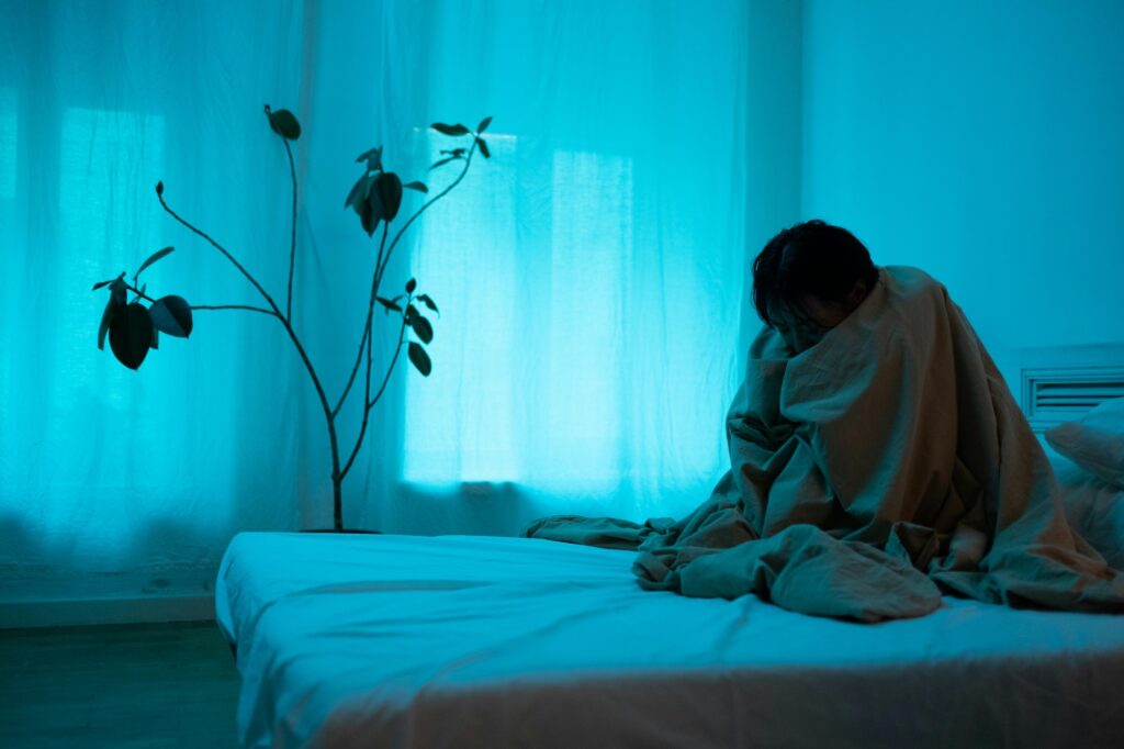 A lonely woman sitting on the bed. Image credit: cottonbro studio, Pexels