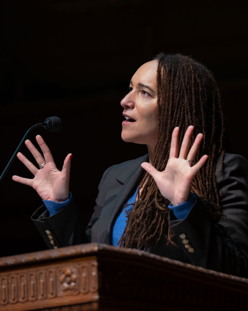 Photo of Tabbye Chavous holding her hands up while speaking at a lectern