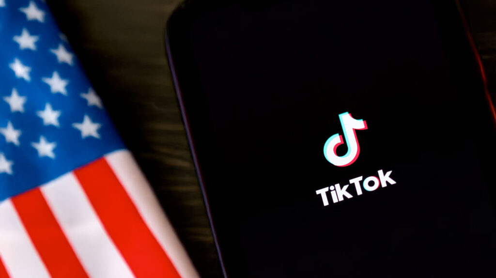 Concept photo of a smart phone showing a TikTok logo with an American flag background. Image credit: Nicole Smith