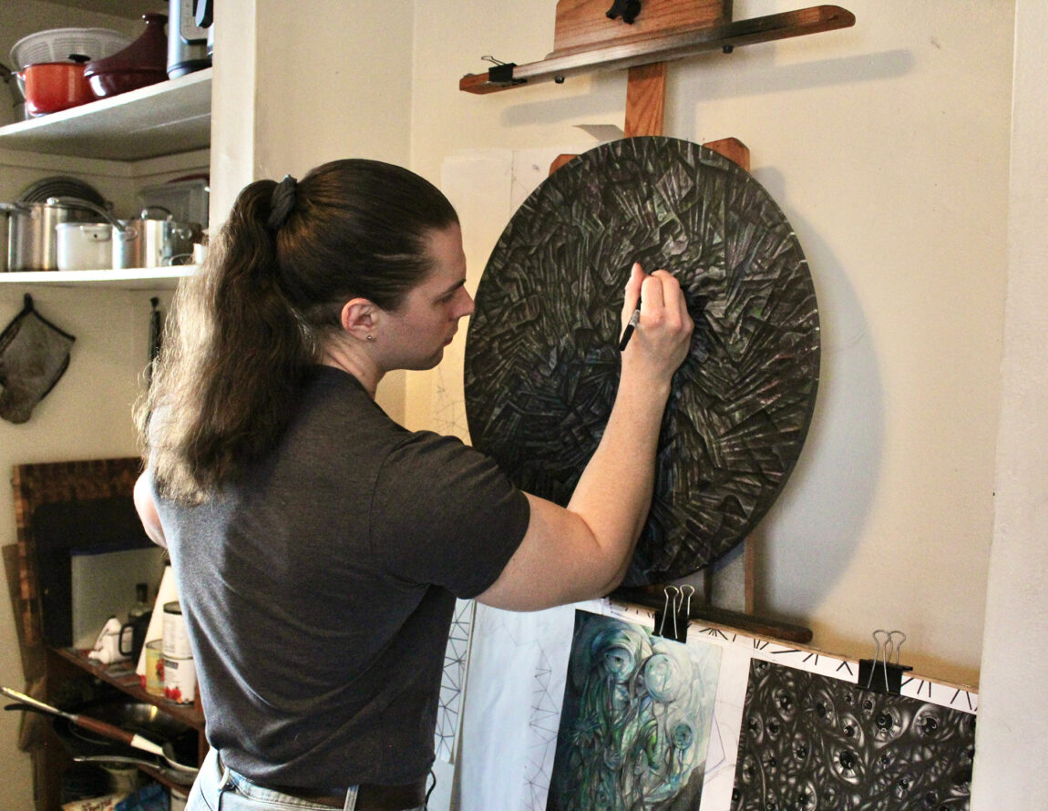 A photo of a man working on a piece of art