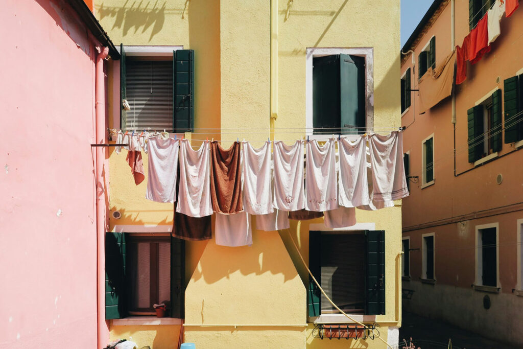 Line drying is common in many countries outside of the United States (as illustrated in this photo from Italy). If Americans relied more on line drying, it could save them hundreds, if not thousands, of dollars over the lifetime of a clothes dryer. Image credit: Katy Cao, Unsplash