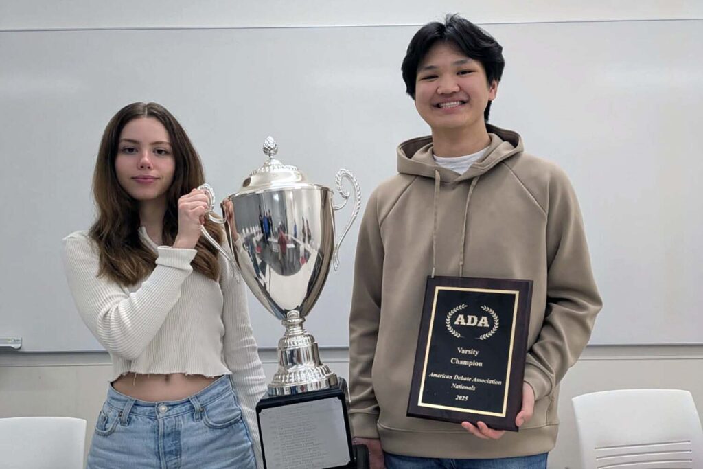 LSA students Eleanor Barrett and Jiyoon Park pose with a trophy and plaque after the U-M Debate Team members won the 38th annual American Debate Association National Championship. Image credit: Aaron Kall