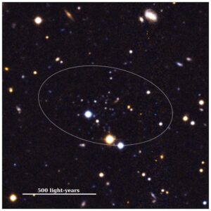 A false-color image taken with MegaCam on the Canada-France-Hawaii Telescope (CFHT) as part of the Pan-Andromeda Archaeological Survey (PAndAS) shows a zoomed-in view of the newly discovered Andromeda XXXV satellite galaxy. A white ellipse, that measures about 1,000 light-years across its longest axis, shows the extent of the galaxy. Within the ellipse's boundary is a cluster of mostly dim stars, ranging in hues from bright blues to warm yellows.