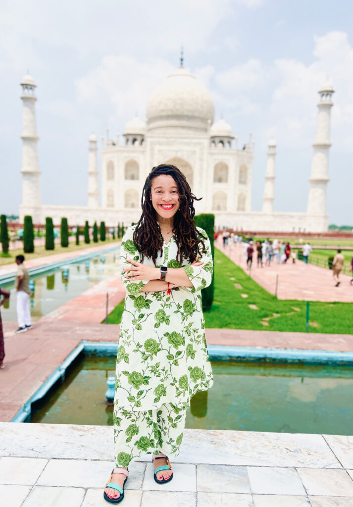 A woman standing in front of the Taj Mahal