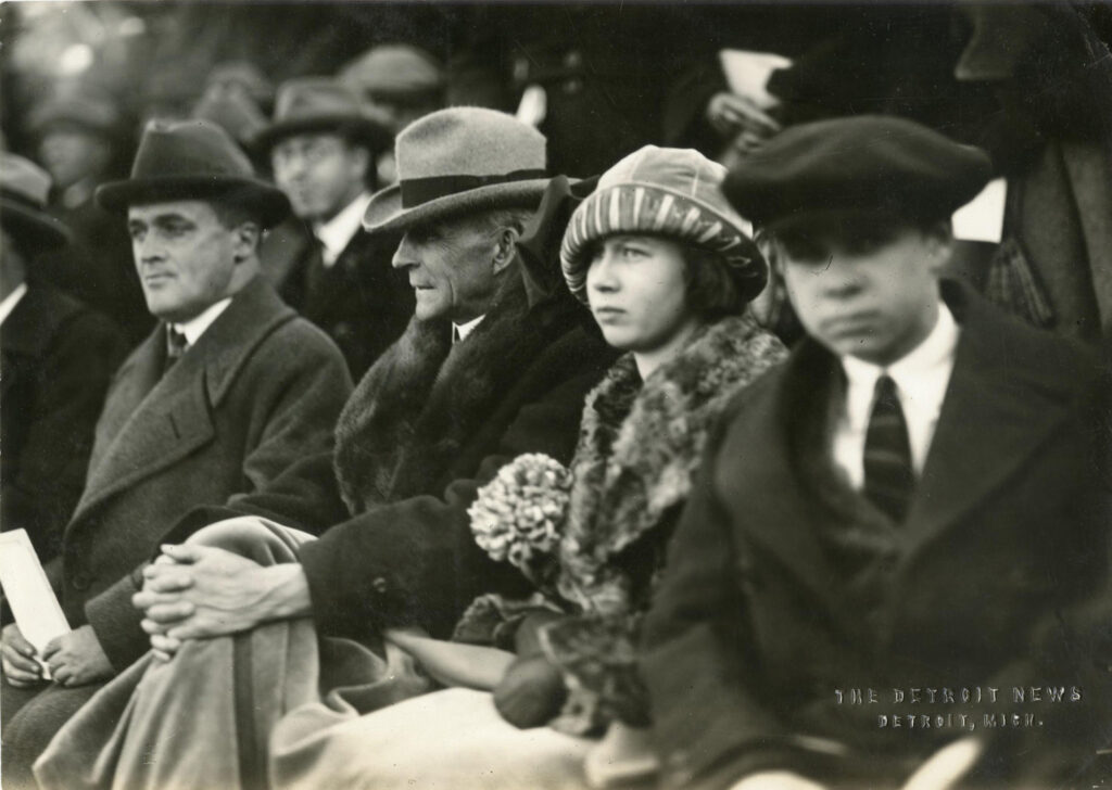 Henry Ford and other people sitting in a row in 1923