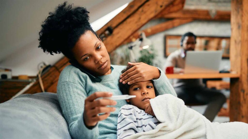 A concerned mom checks her sick child's temperature. Image courtesy: U-M School of Public Health
