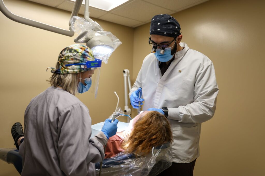 U-M intern Hasan Khaliq attends to patient. Image credit: Jeremy Marble, Michigan News