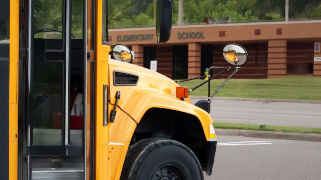 Photo of a bus outside of an elementary school. Image courtesy: U-M Poverty Solutions