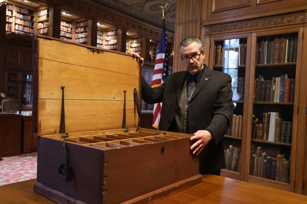 The interior of the roughly 32 x 21 x 12-inch secretarial trunk is of unfinished pine enclosing two levels of pigeonholes. Fourteen slots on each level provide 28 in total. The top tray is removable, and most of the pigeonholes retain paper tags identifying the military post to which the particular correspondence pertained. The trunk was designed to be portable. Gage’s papers moved with him in America and made two Atlantic crossings before arriving in Ann Arbor in 1937. Image credit: Jeremy Marble, Michigan News