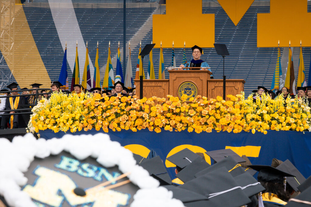 A man stands at a lectern and addresses a crowd