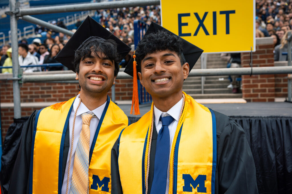 Two men stand together and smile